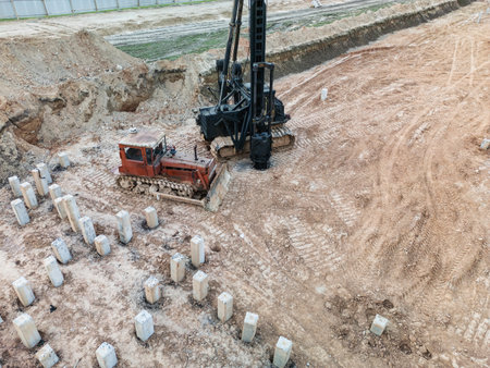 A drilling rig carefully installs concrete pillars at a site, showcasing modern engineering techniques.の写真素材