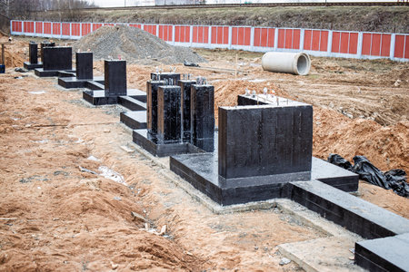 Workers are preparing a new building site, showcasing construction materials and earth in a busy development area.の写真素材