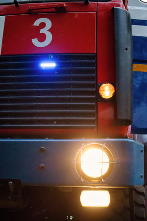 A striking view of an emergency vehicle's front, featuring bright lights and bold colors. The...