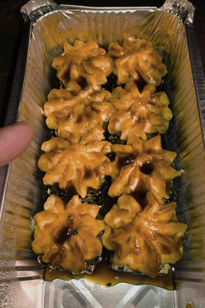 Luscious treats arranged neatly in a silver tray, adorned with caramel and showcasing a beautiful floral design, perfect for sharing at celebratory moments.の写真素材