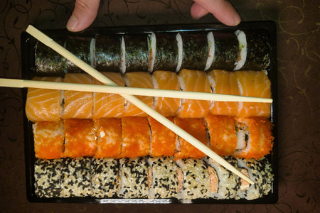 A beautifully arranged sushi platter features a variety of rolls, from vibrant salmon to crispy tempura, ideal for enjoying at a gathering or special occasion.の写真素材