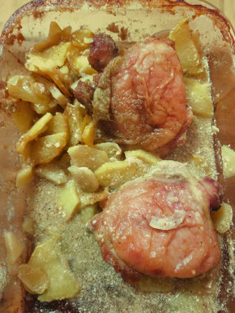 Tender cuts of meat rest beside sweet, golden apples, their rich flavors blending perfectly in a cozy kitchen as evening falls, inviting warmth and comfort.の写真素材