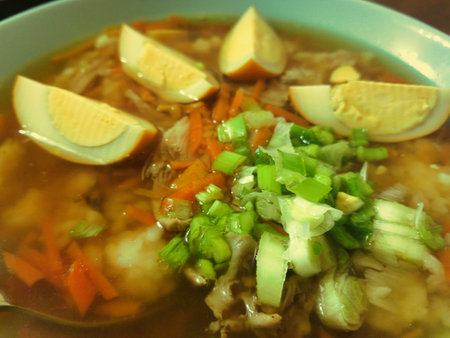 Warm flavors of a traditional noodle soup fill the air as fresh vegetables and boiled eggs create a colorful dish enjoyed during a relaxing dinner.の写真素材