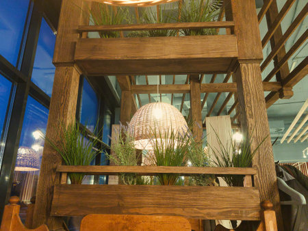 The inviting interior features a unique wooden design adorned with lush plants, illuminated softly, creating a cozy atmosphere for evening gatherings with friends.の写真素材