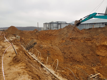 Heavy machinery works diligently on a construction site, focusing on an advanced water lowering system using needle filters to manage groundwater levels effectively.の写真素材