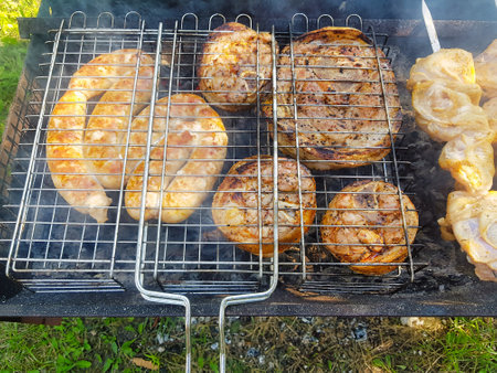 Juicy sausages, hearty steaks, and tender chicken sizzle on the grill, filling the outdoor space with delicious aromas during a vibrant summer afternoon.の写真素材