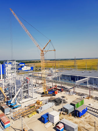 A towering crane looms over a bustling construction site where workers and machinery collaborated to...