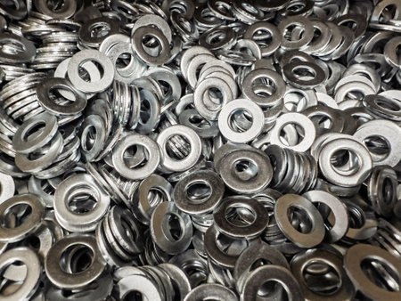 A vast collection of metal washers fills a factory workspace, reflecting the importance of these components in various mechanical applications and assembly processes.の写真素材