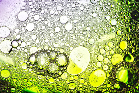 Delicate bubbles dance in vibrant hues, revealing an intricate world of colorful shapes and textures beneath the microscope, inviting curiosity and wonder.の写真素材