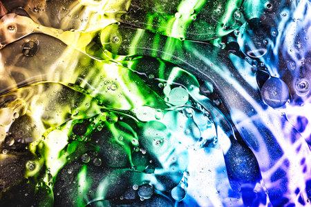 Intricate patterns emerge as vibrant colors swirl and blend, showcasing a mesmerizing abstract world captured under a microscope in stunning detail.の写真素材