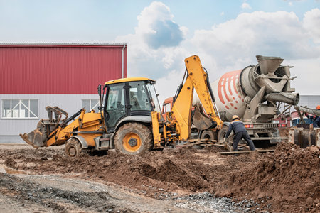 Heavy machinery operates on a construction site, with workers managing tasks involving earthmoving...
