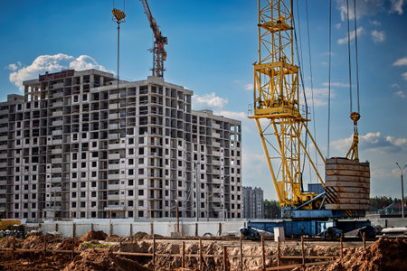 A tower crane stands tall at a construction site, lifting heavy materials for a high-rise building...