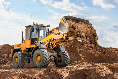 A heavy loader or bulldozer actively digs and moves soil at a construction site. Earthworks....