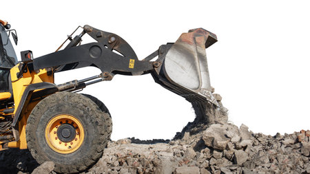 Heavy machinery operates on a construction site, with a wheeled bulldozer or loader using its bucket...