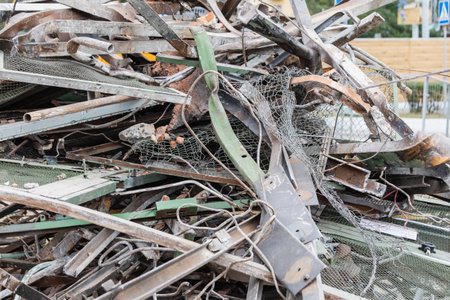 Piles of dismantled metal and debris fill the site of a building demolition in an urban location. Construction activity is ongoing as materials are cleared away.の写真素材