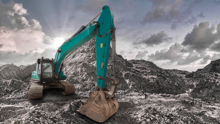An excavator operates on a rocky surface under a cloudy sky, showcasing the power of machinery in construction activities on a rugged terrain.の写真素材