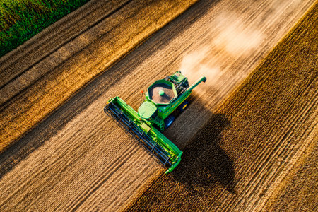 Aerial view of a cabbage harvester in a sunlit field, capturing the vibrant activity of harvest season and the beauty of agriculture.の素材