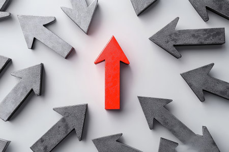 A striking red arrow stands tall among gray arrows on a clean white background, highlighting the importance of focus and determination in achieving success and growth.の素材