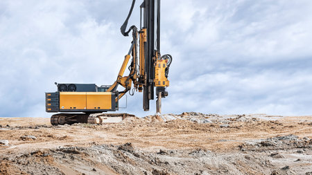 A heavy-duty drilling rig installs bored piles at a construction site. Preparing the pile foundation...