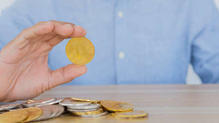 A business man with a coin Bitcoin that can be exchanged for various currencies