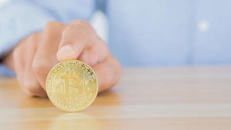 Businessmen tap Bitcoin on the table with their index finger that can be exchanged for large sums of money.の写真素材