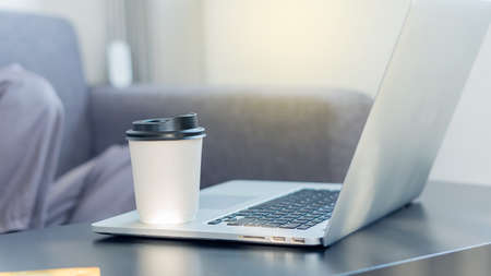 A coffee mug on a businessman's laptop for drowsy drinking