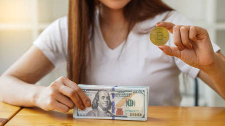 Young women earn a lot of money from businesses holding Bitcoin separately on the table, the concept of cryptocurrency and bitcoineの写真素材