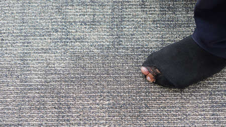 Young man's torn socks with toes sewn on the floor.の写真素材
