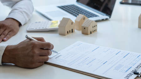 Young man hand holding a pen, contract, insurance concept, home insurance agent, small sample on the...
