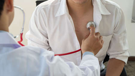 Doctors listen to the patient's heartbeat with a stethoscope, hospital sounds, physical examination, and medical and healthcare concepts with a close-up view.の写真素材