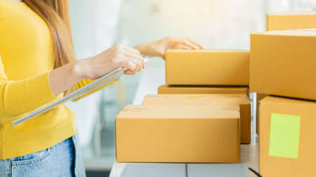 Young Asian selling things online, starting a small business in a working cardboard box Seller...