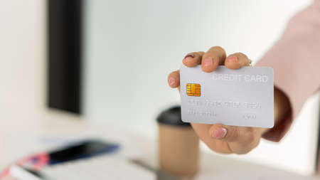 A credit card in the hand of a business woman from a distanceの写真素材