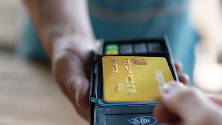 A man who pays the bill by credit card without touching Pay by credit card with NFC technology on the terminal device. Pay at the store with a card reader.の写真素材