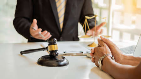 Male attorney advisor or judge advisor concept, having team meetings with clients, legal concepts and hammer attorneys with fair scales on desks in the office.の写真素材