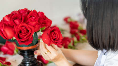 The roses are beautifully arranged by the girl on the table.の写真素材