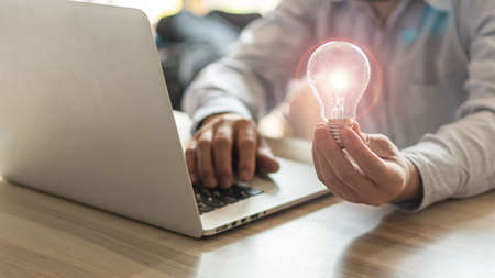 The businessman's hand holds a light bulb. Innovative ideas and inspiration for work