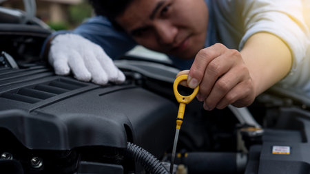 Young man repairing, maintaining and checking cars in a home car repair garage. Car service business...