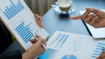 Business people discussing business strategy collaborate during discussions about financial and marketing documents, meetings, data analysis, financial graphs and in-office charts with laptops and calの写真素材