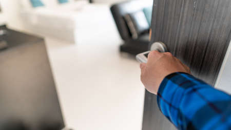 The young man's hand was opening the door to the room.の写真素材