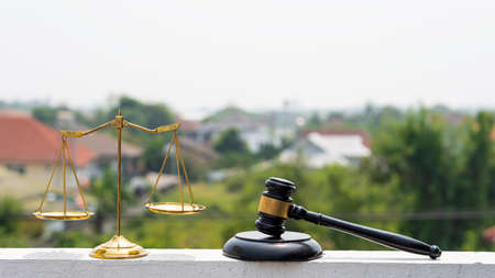 The scales of justice are placed on the wall and the judge hammer on a white background