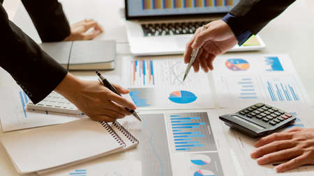 A businessman sits at the graph analysis desk. On graphics and charts with office calculators