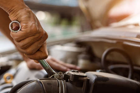 Mechanic in work uniforms, car service Repair and maintenance of broken cars on the side of the...