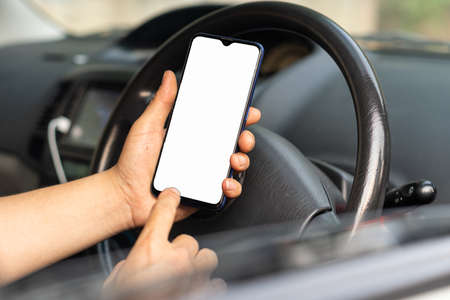 A mobile phone against the background of the steering wheel A phone with a white screen to put...