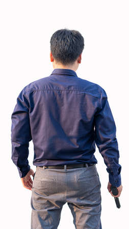 A young Asian man in a blue shirt holds a gun in his hand. White background.の写真素材