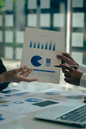 2 business people meeting with pen pointing paper financial graph analysis and investment planning...