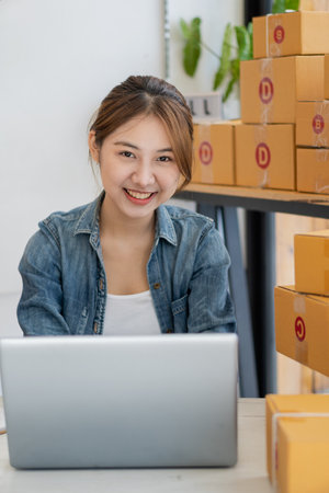Entrepreneur, small business, SME, freelance woman working from home with lots of boxes on the side....