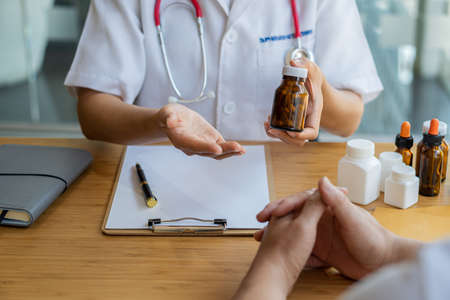 Doctor holding a pen to talk to patient about medication and treatment healthcare and medical concepts The patient listened attentively to the female doctor explaining the patient's conditionの写真素材