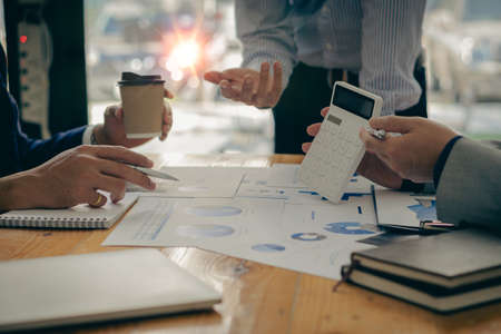 Two business people analyze a graph of financial data and a laptop computer. Corporate financial investment advisor concept image for the stock market, office, tax, and projects.の写真素材