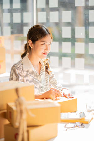 Starting a small business SME female entrepreneur Use a laptop or notebook to pick up and check...