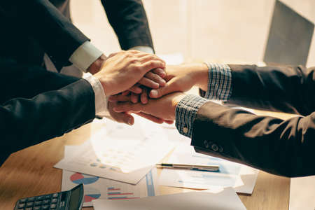 Businesses shake hands and business people join hands to make a business deal together at the...